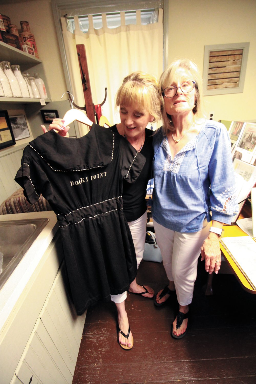 SUITED FOR SWIMMING: Cindy Martin Trahan and Cheryl Sprague Fernstrom size up a Rocky Point bathing suit that at one time the park rented to patrons. They didn’t try it on.